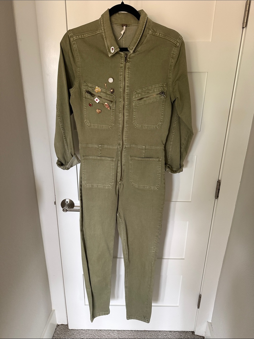 Army green jumpsuit with pins added for style.
